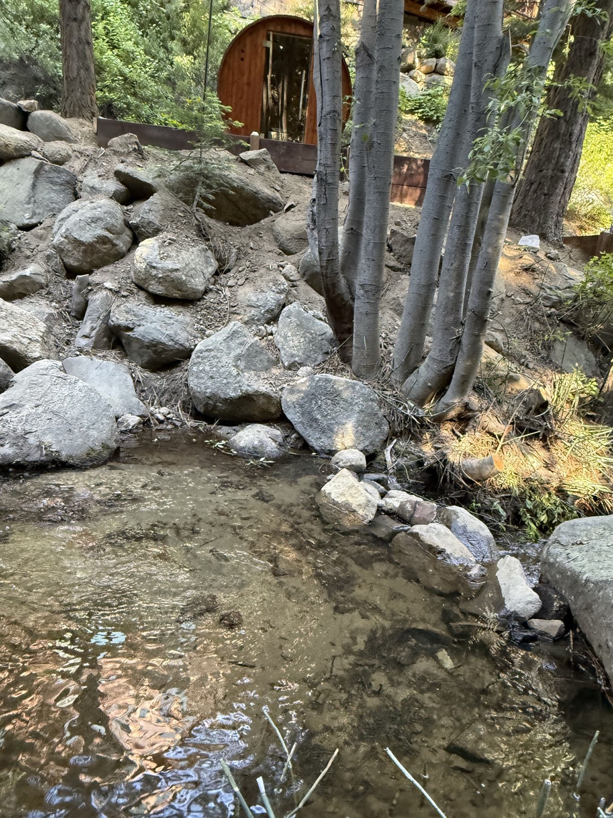 Second Creek running cold over granite boulders steps from the sauna — a natural cold plunge
